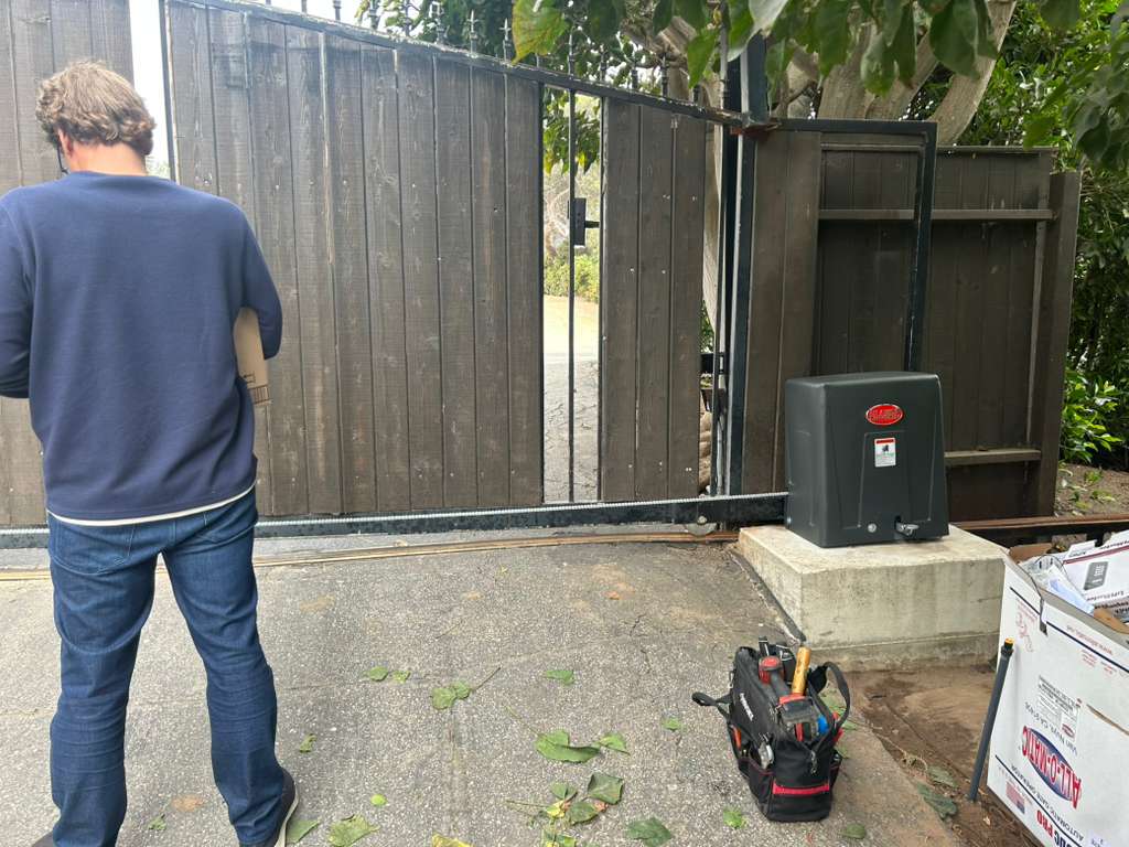 Man in front of wooden gate with installed gate opener