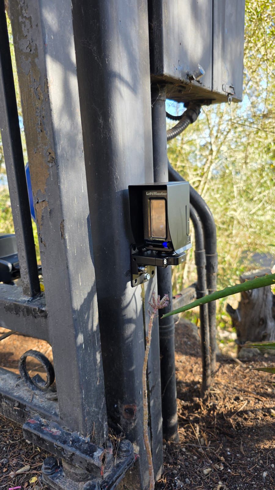 LiftMaster safety sensor mounted on black gate post in Santa Monica, CA