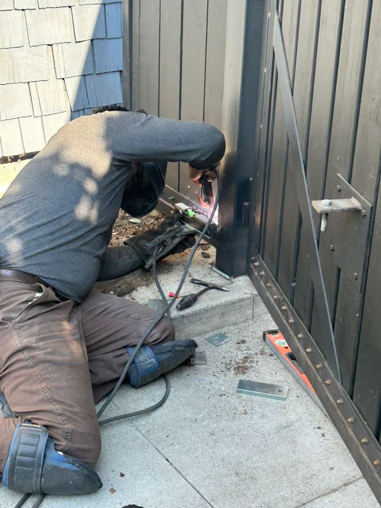 Welder repairing metal gate, sparks flying, close up view. in Santa Monica, CA